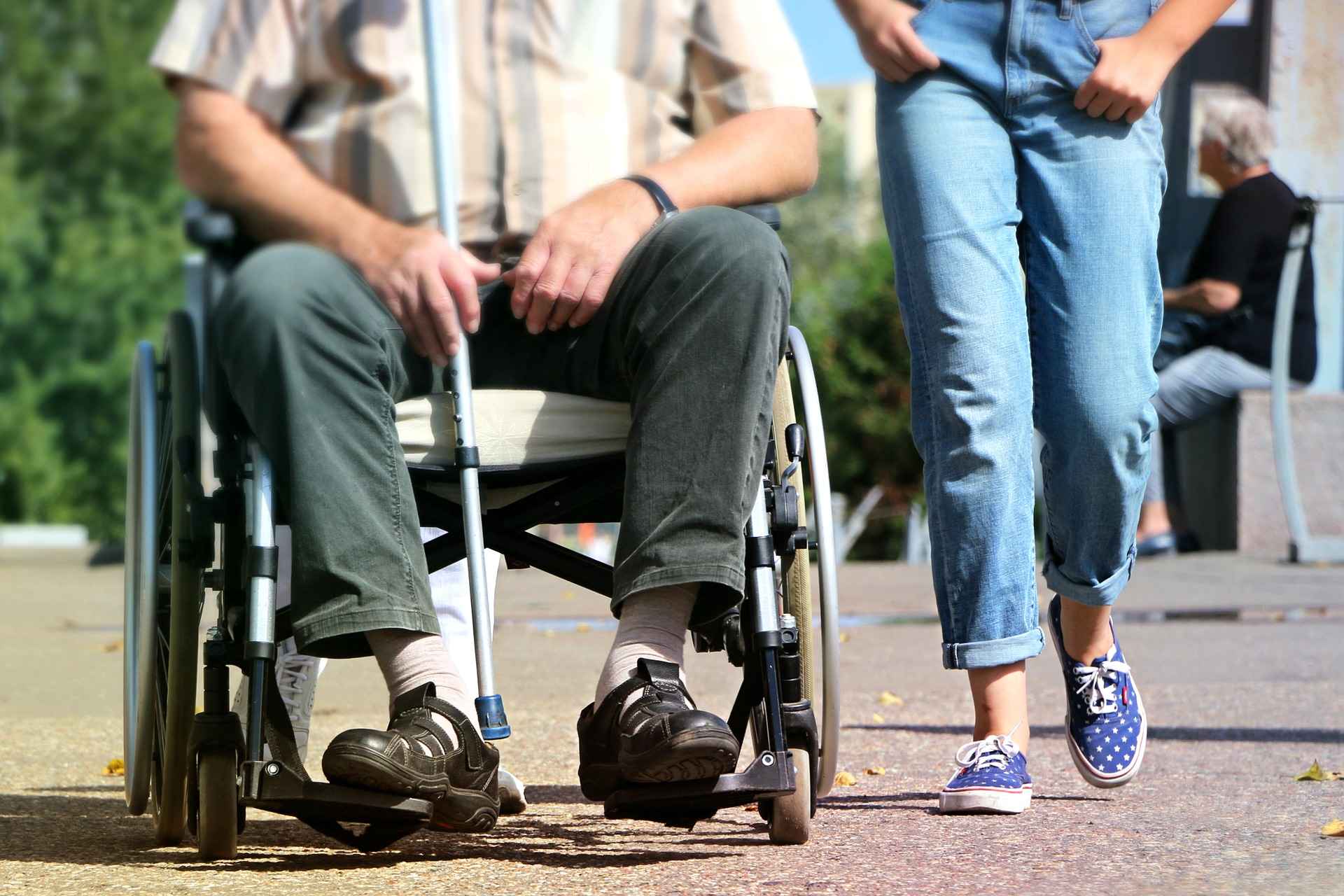 En kørestolsbruger med multipel sklerose og en kvinde der går