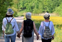 Tre kvinder går en tur og holder hinanden i hænderne